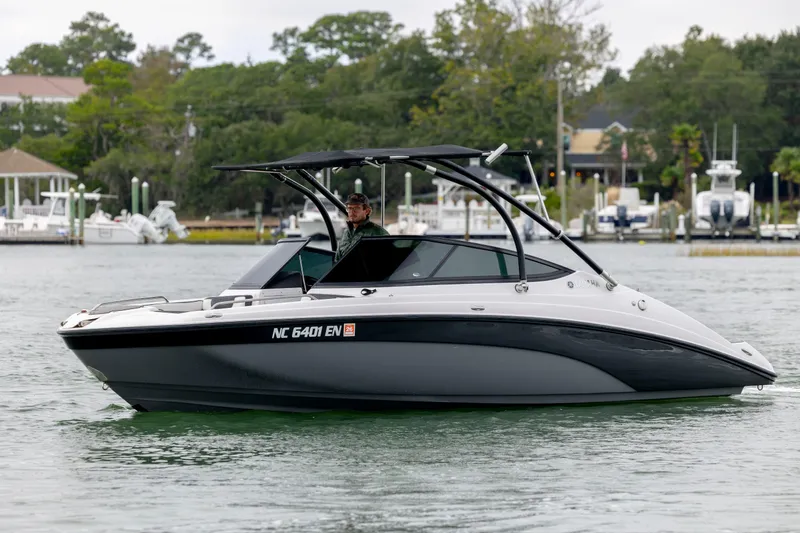 The Image of 2017 Yamaha Boats SX210 on water, sleek design, black and white color, marina background. - 0