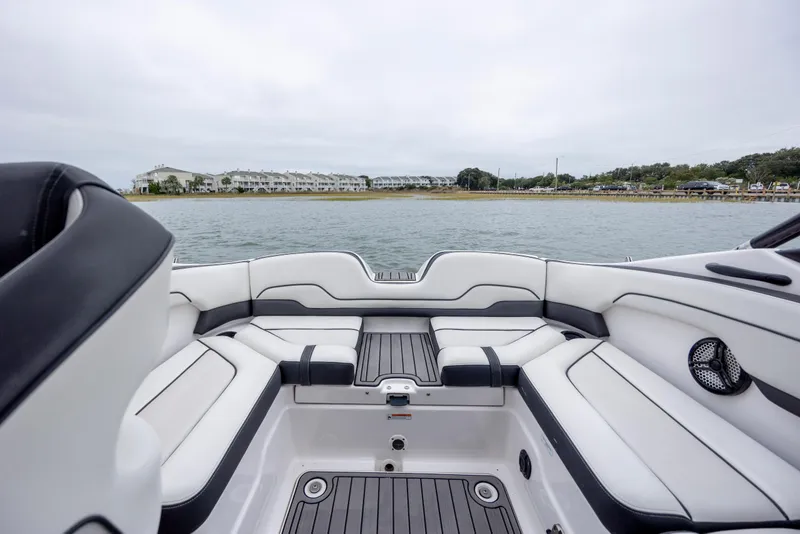 Slide: The Image of 2017 Yamaha Boats SX210 interior with white seating, overlooking calm waters and distant shoreline. - 3
