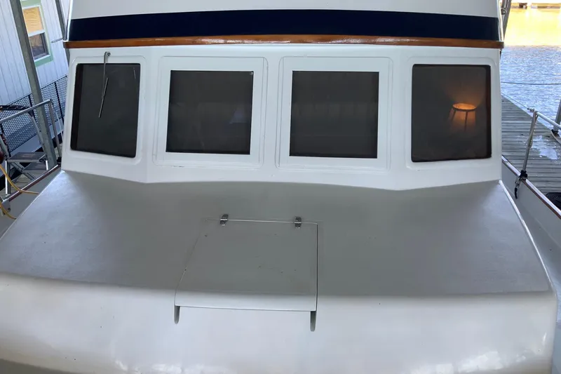 Slide: The Image of 1976 Cheoy Lee 40 LRC yacht with three large windows, docked by the water. - 10
