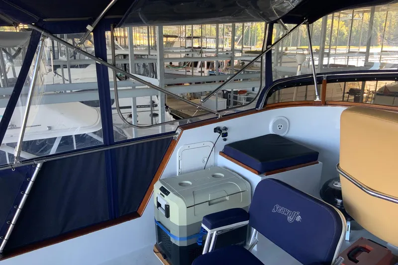 Slide: The Image of 1976 Cheoy Lee 40 LRC yacht interior with seating and cooler, docked in a marina. - 18