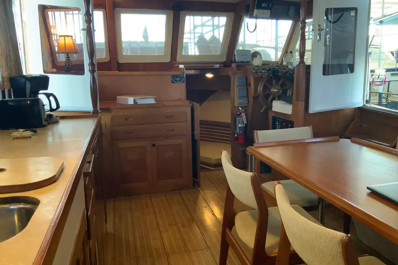 Slide: The Image of 1976 Cheoy Lee 40 LRC yacht interior with wooden furnishings and dining area. - 26