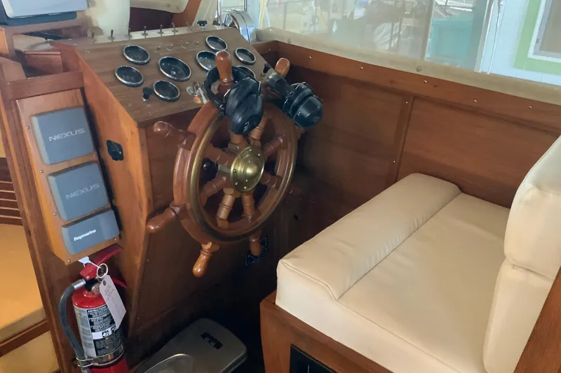 Slide: The Image of 1976 Cheoy Lee 40 LRC helm with wooden wheel, gauges, and cushioned seating. - 37