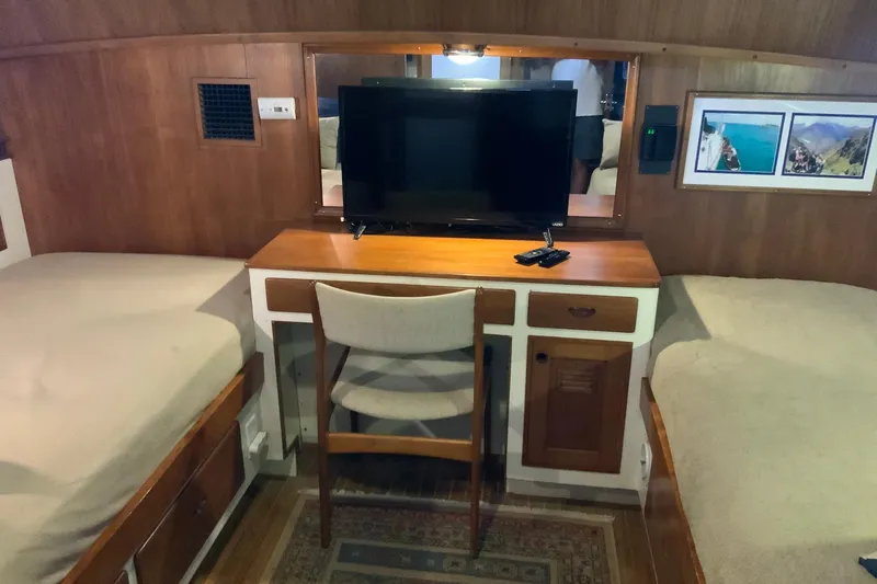 Slide: The Image of 1976 Cheoy Lee 40 LRC cabin interior with TV, desk, and twin beds. - 43