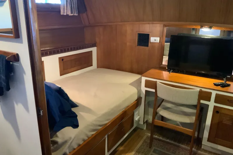 Slide: The Image of Cozy cabin interior of 1976 Cheoy Lee 40 LRC with bed, desk, and TV. - 44