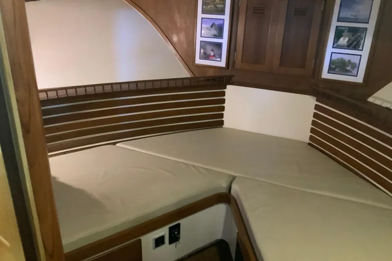 Slide: The Image of 1976 Cheoy Lee 40 LRC cabin interior with wooden accents and cushioned seating. - 49