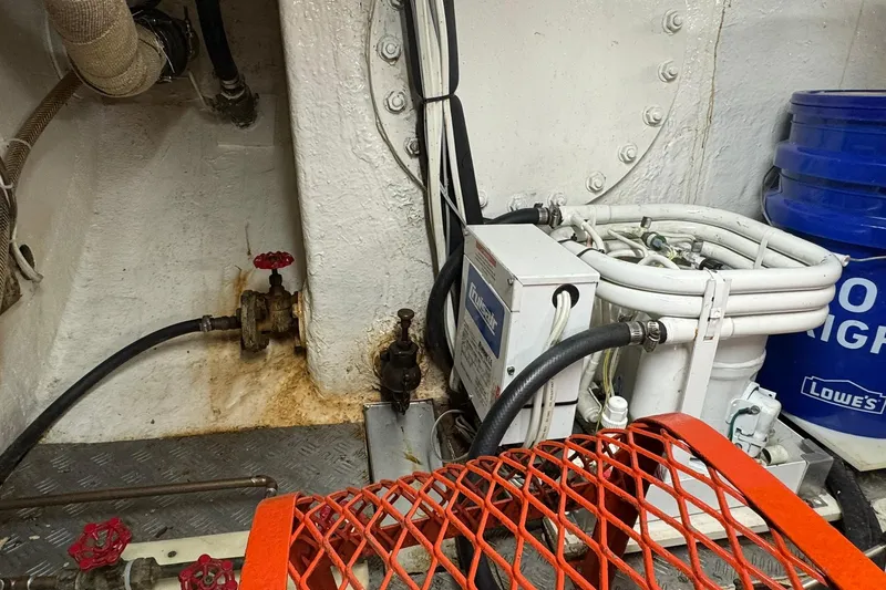 Slide: The Image of Engine room of a 1976 Cheoy Lee 40 LRC with mechanical components and piping. - 54