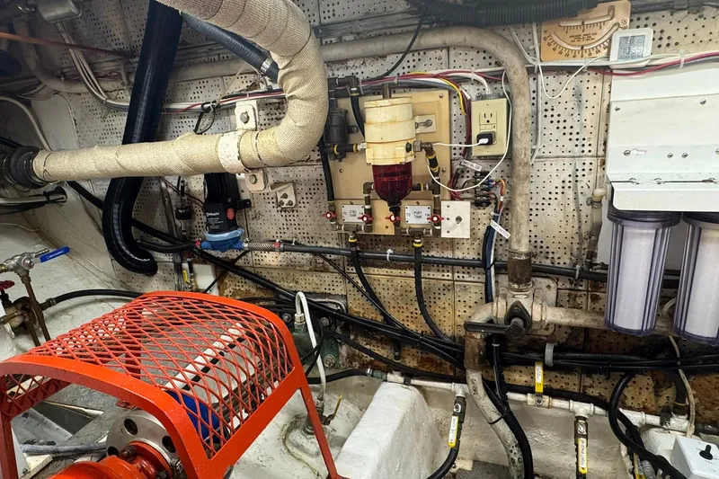 Slide: The Image of Engine room of a 1976 Cheoy Lee 40 LRC with visible pipes and filters. - 58