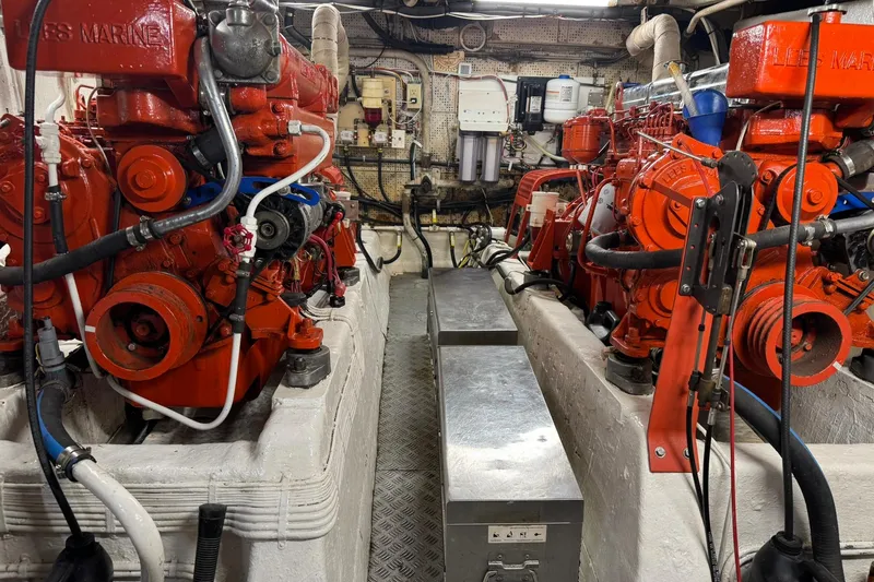 Slide: The Image of Engine room of a 1976 Cheoy Lee 40 LRC with twin red marine engines. - 60
