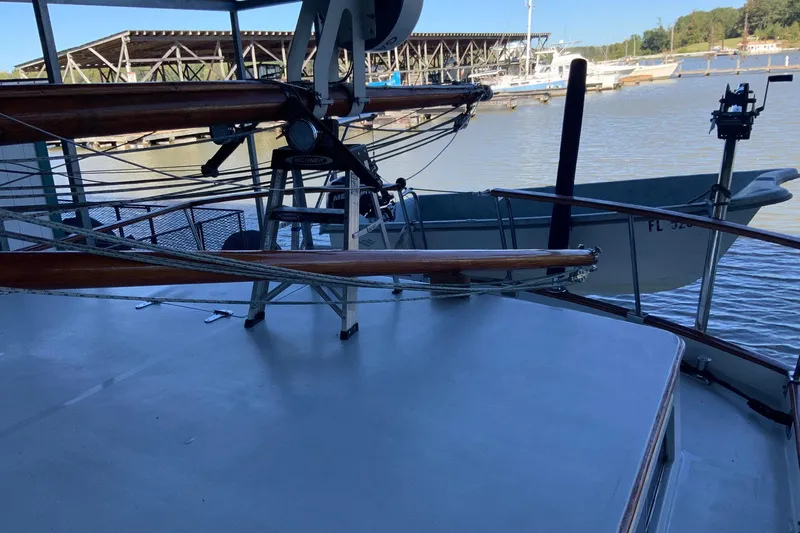 Slide: The Image of 1976 Cheoy Lee 40 LRC yacht deck with docked boats in marina background. - 7