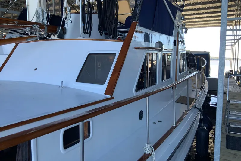 Slide: The Image of 1976 Cheoy Lee 40 LRC yacht docked, showcasing sleek design and wooden accents. - 8