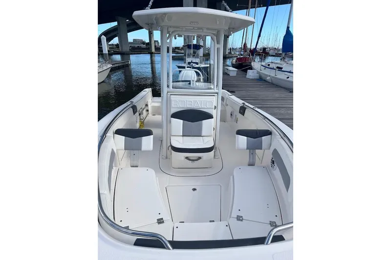 Slide: The Image of 2022 Robalo R242 Center Console boat docked at marina, showcasing spacious seating. - 2