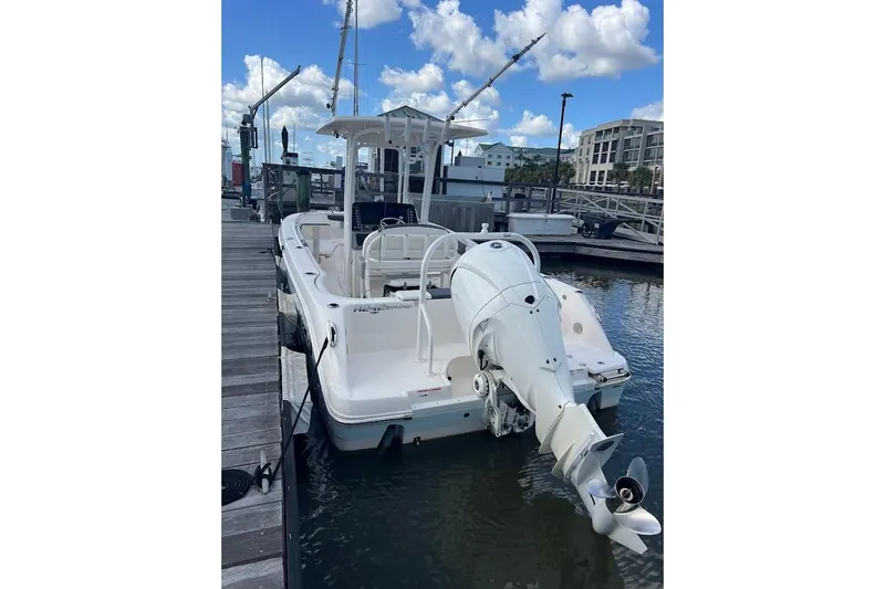 Slide: The Image of 2022 Robalo R242 Center Console boat docked at marina under blue sky. - 5