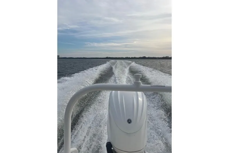 Slide: The Image of 2022 Robalo R242 Center Console boat cruising on open water, leaving a wake trail. - 8