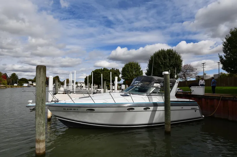 The Image of 1990 Formula boat docked at a marina under a partly cloudy sky. - 1