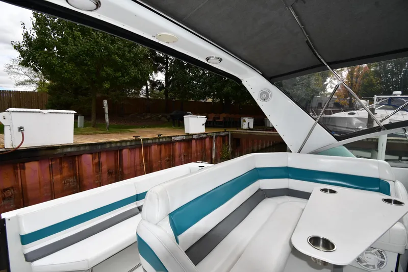 Slide: The Image of Interior of a 1990 Formula boat with white and teal seating at a dock. - 15