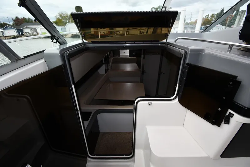 Slide: The Image of 1990 Formula boat cabin interior with seating and open hatch, dockside view. - 17