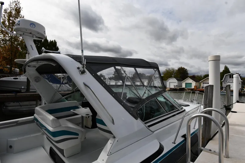 Slide: The Image of 1990 Formula boat docked at marina under cloudy sky. - 2