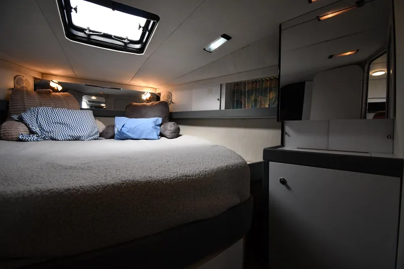 Slide: The Image of Cozy 1990 Formula boat cabin interior with bed, pillows, and soft lighting. - 20