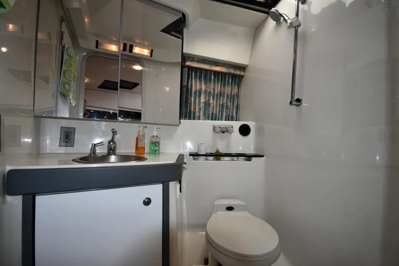 Slide: The Image of 1990 Formula boat bathroom with sink, toilet, shower, and mirrored cabinet. - 26