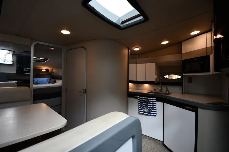 Slide: The Image of Interior of a 1990 Formula boat featuring a cozy kitchen and sleeping area. - 27