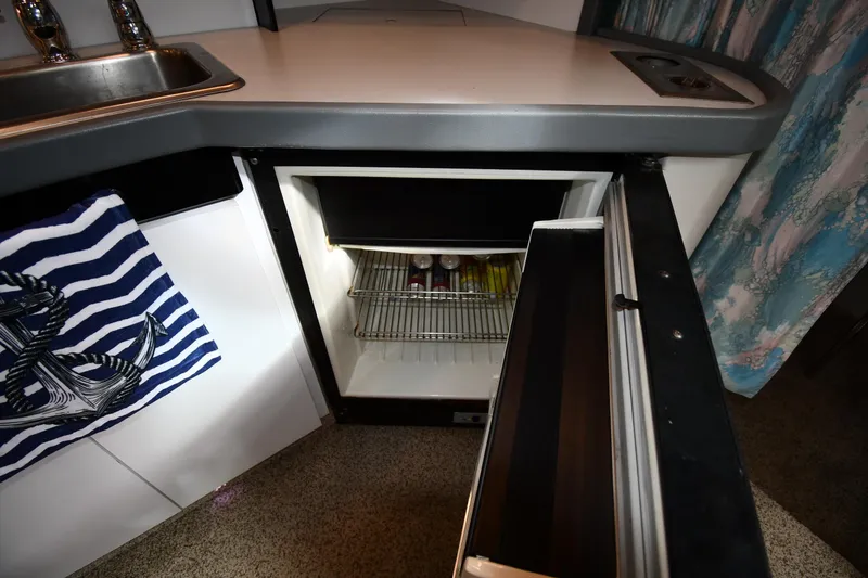 Slide: The Image of Compact kitchen area with open mini fridge, striped towel, and sink in a 1990 Formula model. - 34