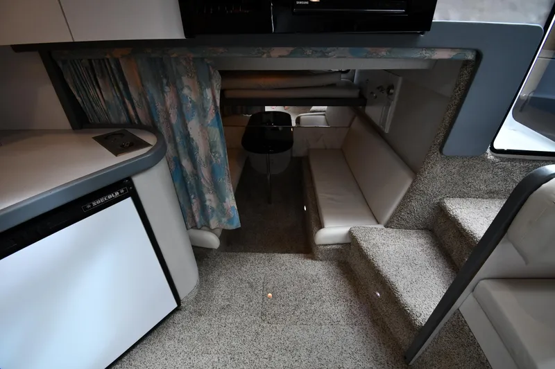 Slide: The Image of 1990 Formula boat interior with seating, table, and compact kitchen area. - 35