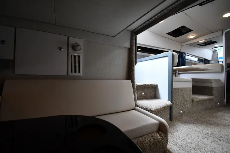 Slide: The Image of Interior of a 1990 Formula boat, featuring seating and carpeted steps. - 38