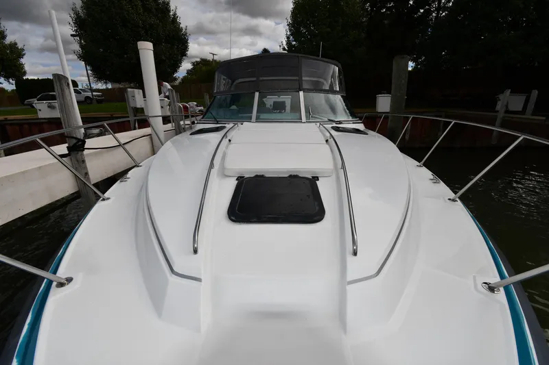 Slide: The Image of 1990 Formula boat docked, featuring sleek white deck and windshield, surrounded by trees. - 5