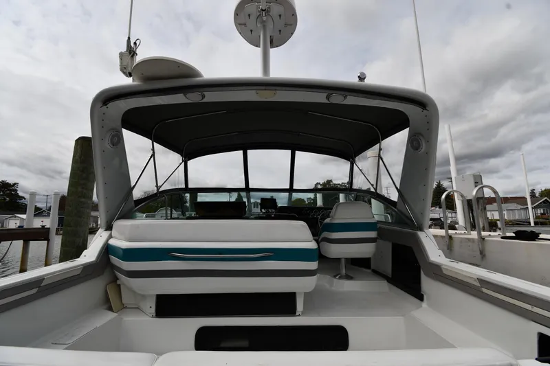 Slide: The Image of 1990 Formula boat interior with striped seats, docked under cloudy skies. - 8