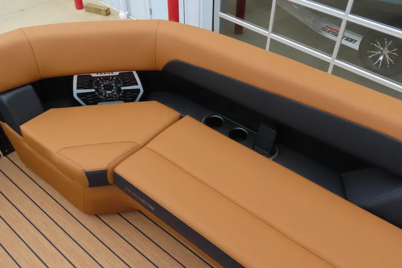 Slide: The Image of 2025 Princecraft Vogue 25 RL boat interior with tan and black seating, cup holders, and sleek design. - 25