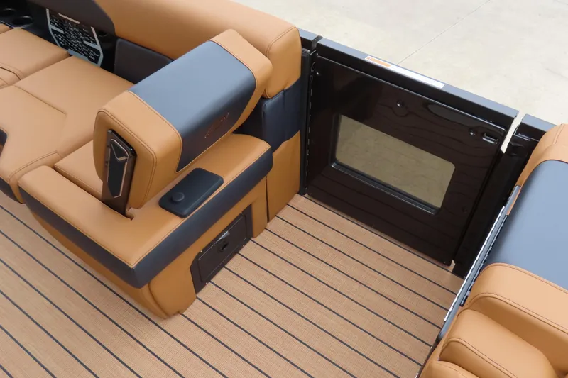 Slide: The Image of 2025 Princecraft Vogue 25 RL interior with tan and black seating, open gate, and striped flooring. - 27