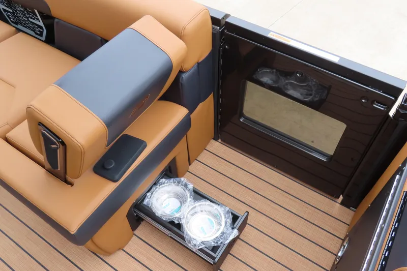 Slide: The Image of 2025 Princecraft Vogue 25 RL boat interior with tan and black seating, and storage drawer. - 28