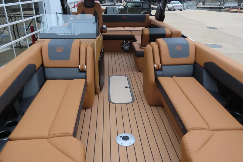 Slide: The Image of Luxurious interior of 2025 Princecraft Vogue 25 RL pontoon boat with tan seating and wood flooring. - 9