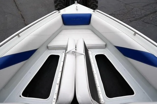 Slide: The Image of 1992 Celebrity 180 Bowrider boat interior with white and blue seating, open storage compartments. - 10