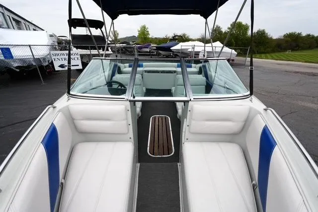 Slide: The Image of 1992 Celebrity 180 Bowrider boat interior with white and blue seating, showroom background. - 11