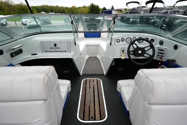 Slide: The Image of Interior of a 1992 Celebrity 180 Bowrider boat with white seating and dashboard controls. - 12