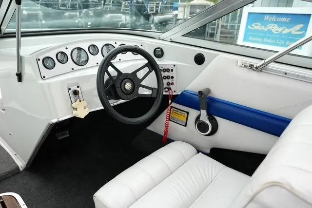 Slide: The Image of Interior of a 1992 Celebrity 180 Bowrider boat with steering wheel and dashboard controls. - 13