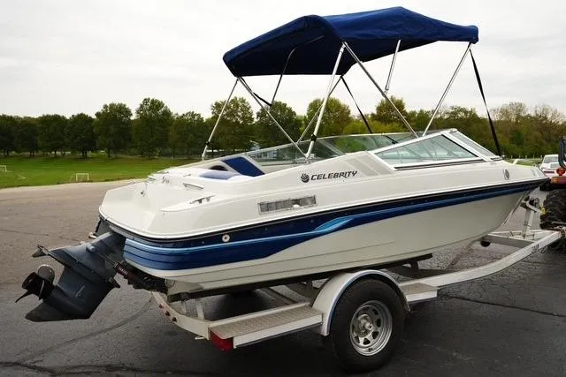 Slide: The Image of 1992 Celebrity 180 Bowrider boat on trailer with blue canopy, parked outdoors. - 4