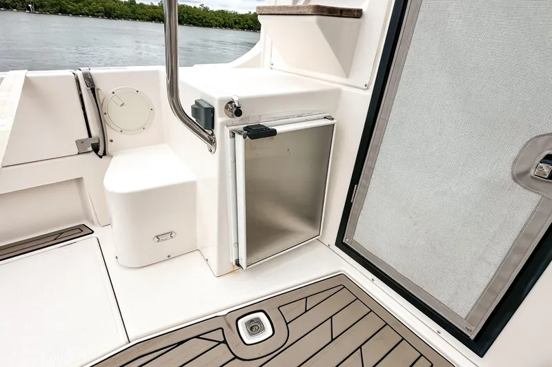 Slide: The Image of 2022 Cutwater 30 Command Bridge boat interior with stainless steel door and seating area. - 10