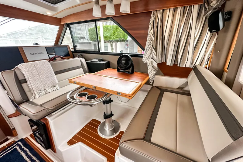 Slide: The Image of Interior of 2022 Cutwater 30 Command Bridge with seating, table, and Garmin navigation system. - 18