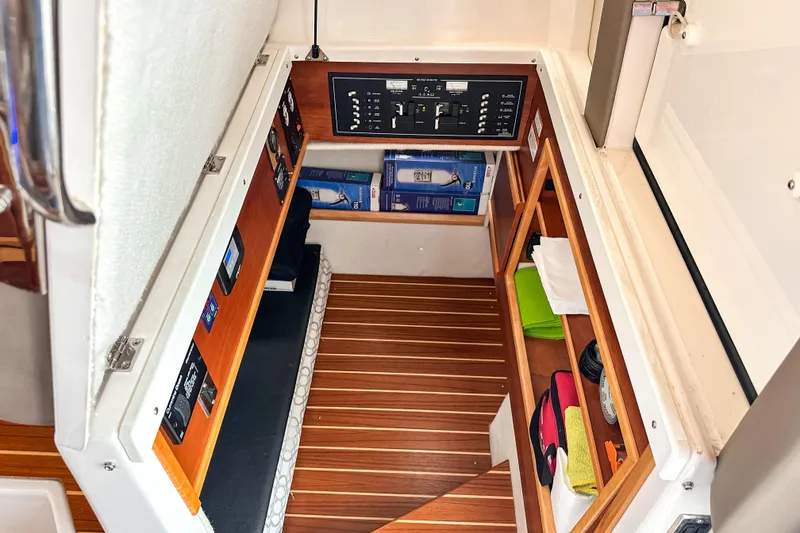 Slide: The Image of 2022 Cutwater 30 Command Bridge interior storage with control panel and wooden flooring. - 24