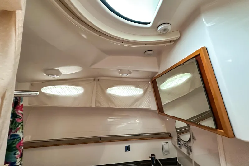 Slide: The Image of Interior of 2022 Cutwater 30 Command Bridge bathroom with skylight and mirror. - 31