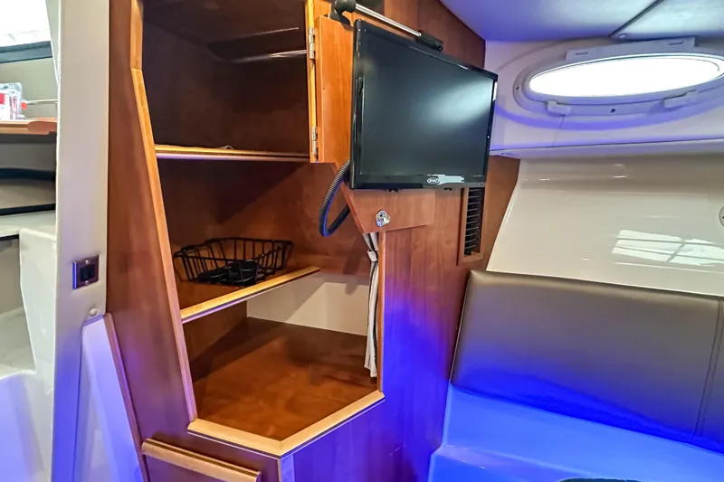 Slide: The Image of 2022 Cutwater 30 Command Bridge interior with TV, wooden shelves, and seating area. - 38