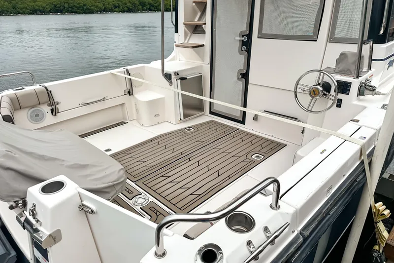 Slide: The Image of 2022 Cutwater 30 Command Bridge boat interior with teak flooring and steering wheel. - 4
