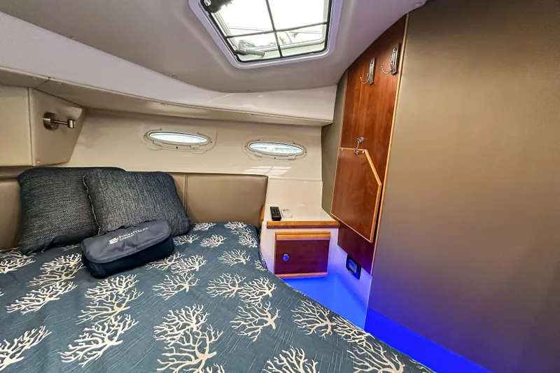 Slide: The Image of Cozy cabin interior of 2022 Cutwater 30 Command Bridge with elegant bedding and wood accents. - 40