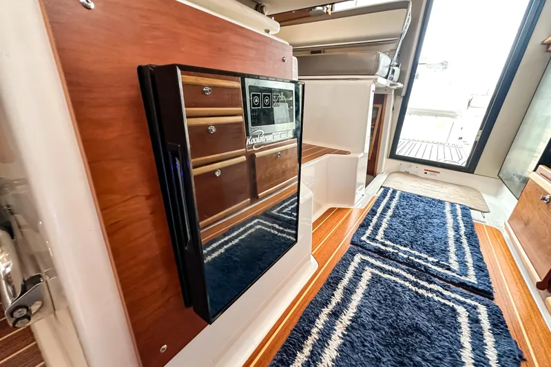 Slide: The Image of 2022 Cutwater 30 Command Bridge interior with wood accents and blue rug. - 43