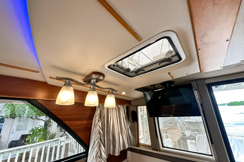 Slide: The Image of Interior of 2022 Cutwater 30 Command Bridge with modern lighting and ceiling hatch. - 45