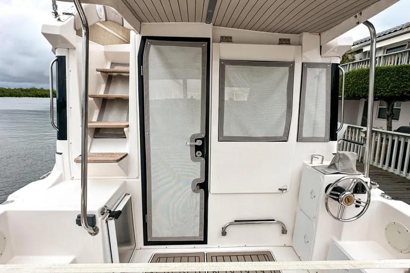 Slide: The Image of 2022 Cutwater 30 Command Bridge boat interior with stairs, door, and steering wheel. - 5