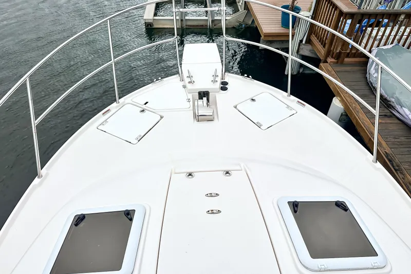 Slide: The Image of 2022 Cutwater 30 Command Bridge boat deck with hatches and railing at dock. - 54