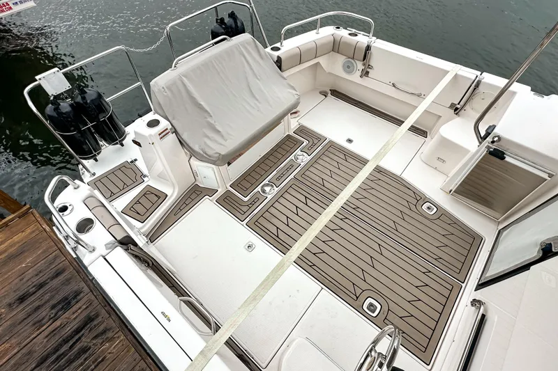 Slide: The Image of 2022 Cutwater 30 Command Bridge boat deck with seating and storage, docked by the water. - 56